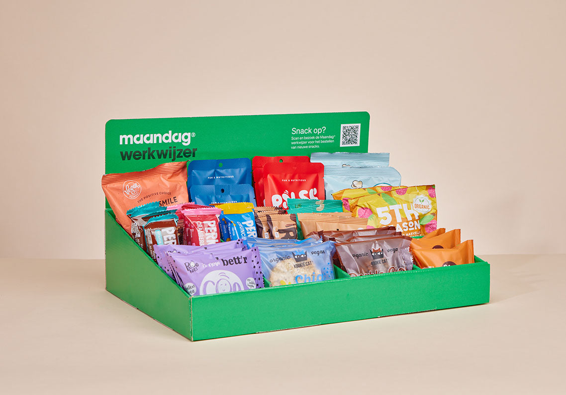 Een groene, gepersonaliseerde JustBite displaydoos voor Maandag Werkwijzer gevuld met een divers assortiment aan bewuste snacks.