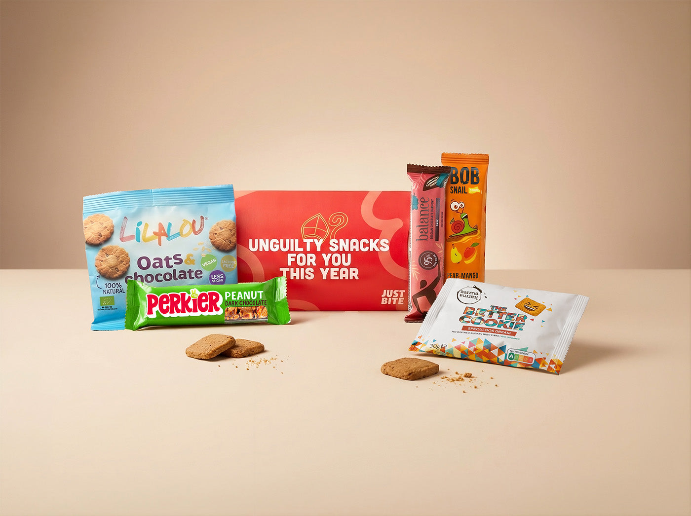Feestelijk rood brievenbusdoosje gevuld als verrassend lekker JustBite sinterklaaspakket voor personeel. Met smaakvolle haverkoeken, betere speculoos en fruitige snacks geven we een moderne, bewuste twist aan Sinterklaas.