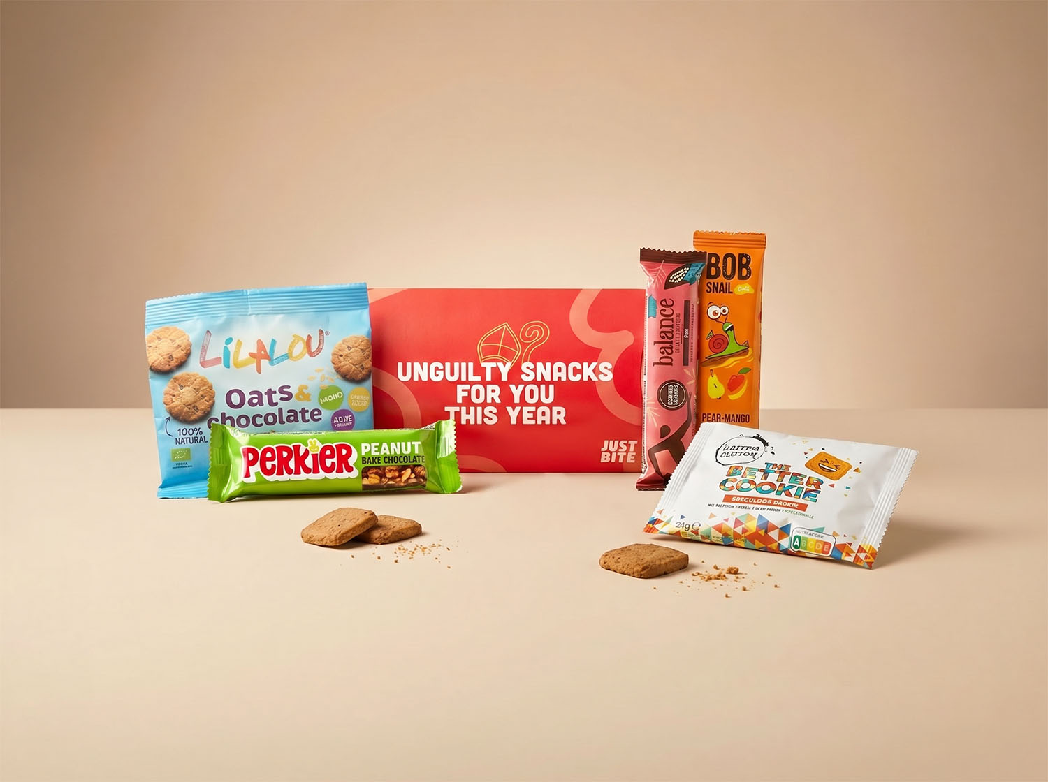 Feestelijk rood brievenbusdoosje gevuld als verrassend lekker JustBite sinterklaaspakket voor personeel. Met smaakvolle haverkoeken, betere speculoos en fruitige snacks geven we een moderne, bewuste twist aan Sinterklaas.