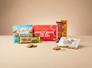 Feestelijk rood brievenbusdoosje gevuld als verrassend lekker JustBite sinterklaaspakket voor personeel. Met smaakvolle haverkoeken, betere speculoos en fruitige snacks geven we een moderne, bewuste twist aan Sinterklaas.