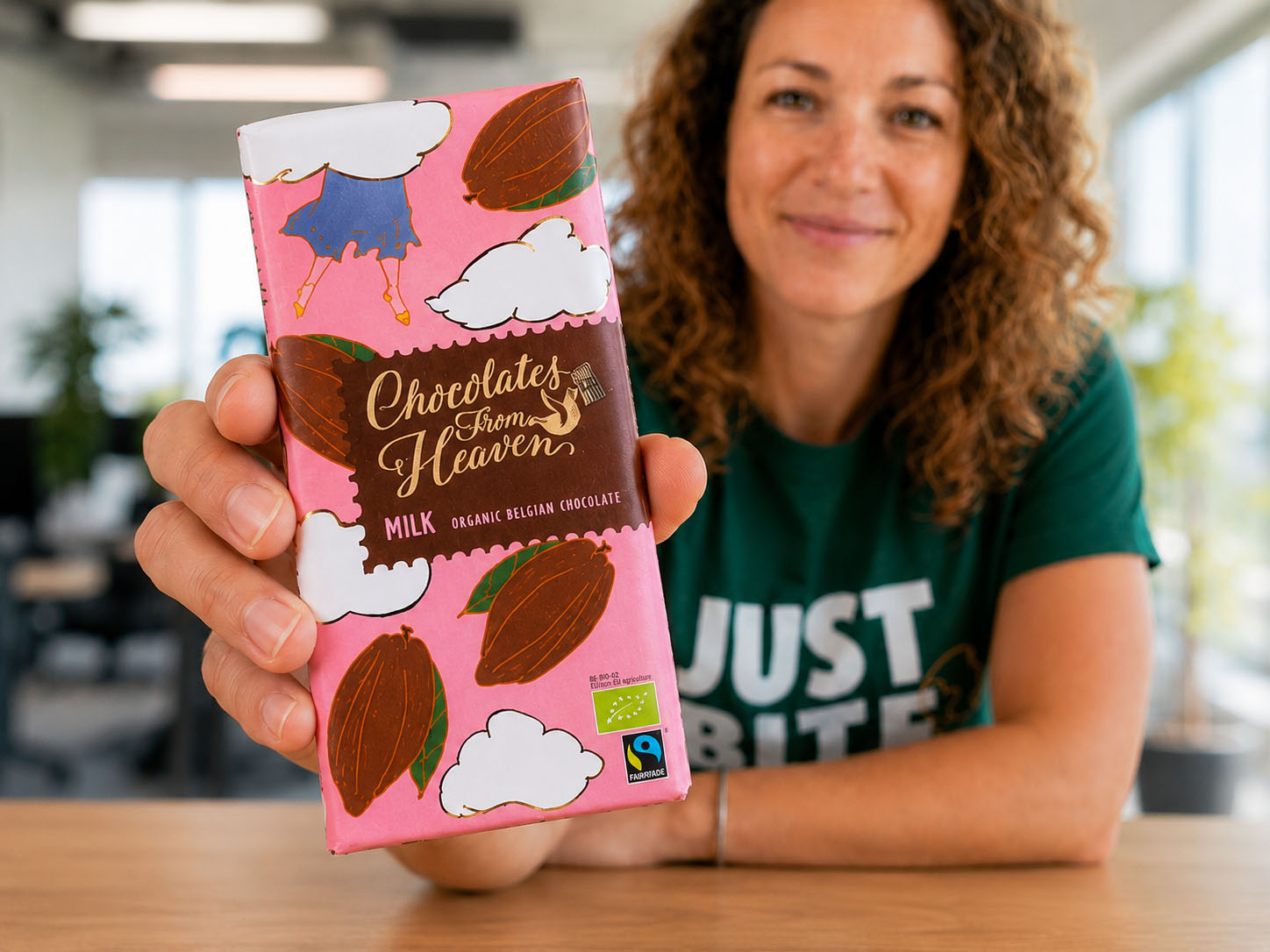 JustBite-collega toont trots een verrassend lekkere reep biologische chocolade van Chocolates From Heaven. Beter snacken betekent bij ons ook een eerlijke keten: wij selecteren fairtrade snacks zodat jouw team un-guilty kan genieten.