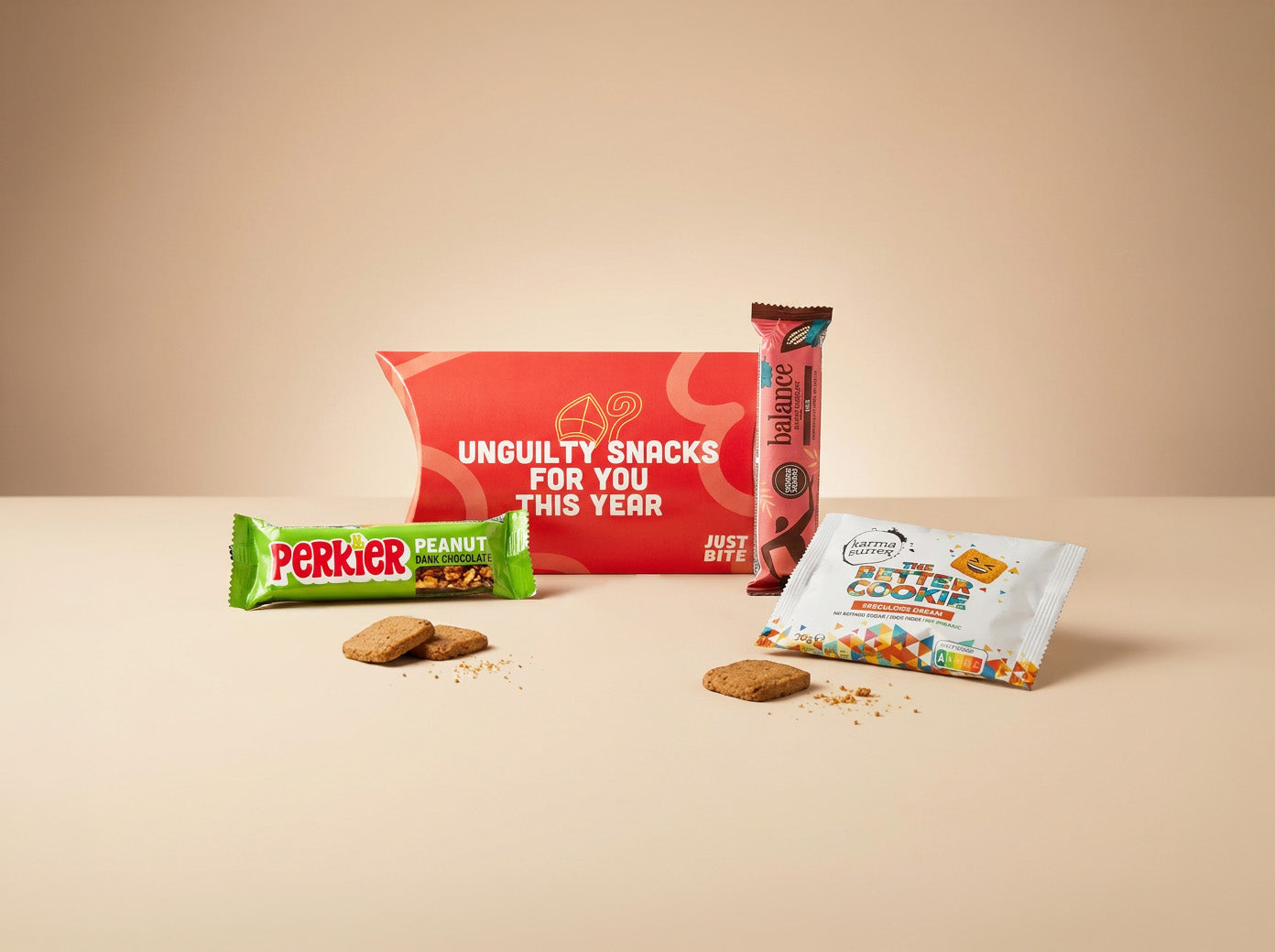 Klein maar smaakvol JustBite sinterklaaspakket voor personeel in een rode geschenkverpakking. Een un-guilty traktatie met knapperige betere speculoos en donkere chocolade, waarmee we bewuste verwennerij makkelijk maken voor elke medewerker.