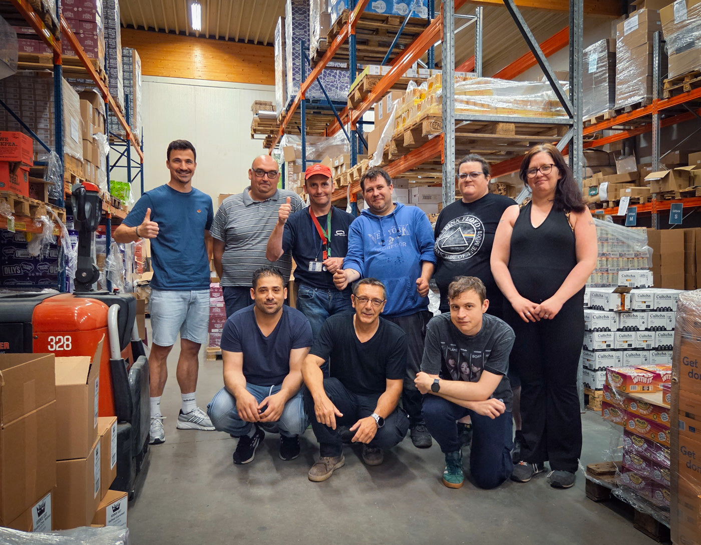 Groepsfoto van operations manager Matthias samen met ons trotse team van maatwerkers in het JustBite magazijn. Beter snacken betekent voor ons ook een positieve maatschappelijke impact: we bouwen bewust aan een inclusieve werkplek waar iedereen met zijn eigen talenten bijdraagt.