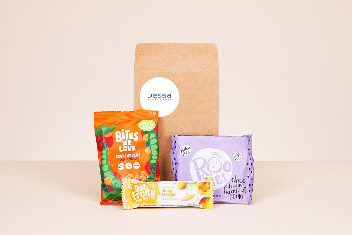 Een geschenkenvelop met een gepersonaliseerde sticker van het Jessa Ziekenhuis, omringd door bewuste snacks.